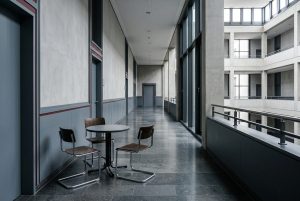 Drei Stühle um einen Tisch im Flur eines Justizgebäudes