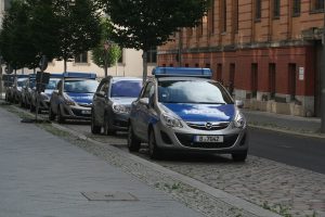 Mehrere Streifenwagen der Polizei Berlin parken vor einem Backsteingebäude